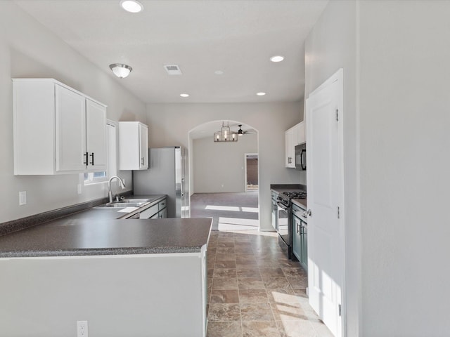6409 Osprey Dr NE, Rio Rancho, NM 87144 - kitchen featuring kitchen peninsula, stainless steel gas range oven, ceiling fan, sink, and white cabinets