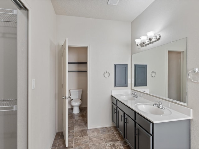 6409 Osprey Dr NE, Rio Rancho, NM 87144 - bathroom featuring vanity, a textured ceiling, and toilet