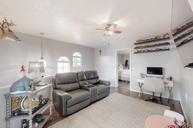 living room featuring a textured ceiling, dark hardwood / wood-style floors, and ceiling fan