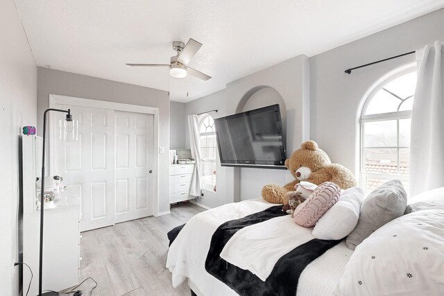 bedroom featuring ceiling fan, light wood-type flooring, and a closet