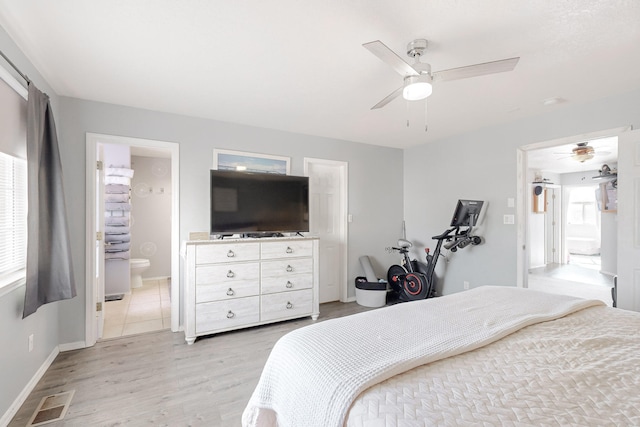 bedroom with ensuite bathroom, light hardwood / wood-style flooring, and ceiling fan