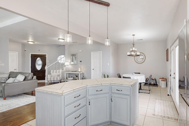 kitchen featuring pendant lighting, a center island, light tile patterned floors, and a healthy amount of sunlight