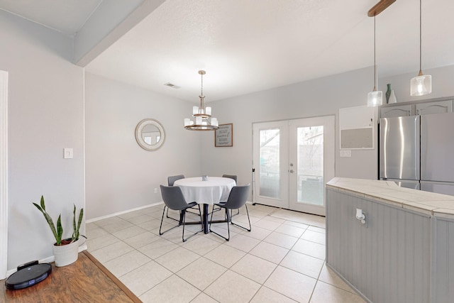 tiled dining room featuring french doors and an inviting chandelier