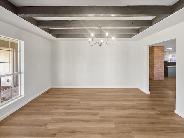 unfurnished dining area featuring hardwood / wood-style flooring, beam ceiling, and an inviting chandelier