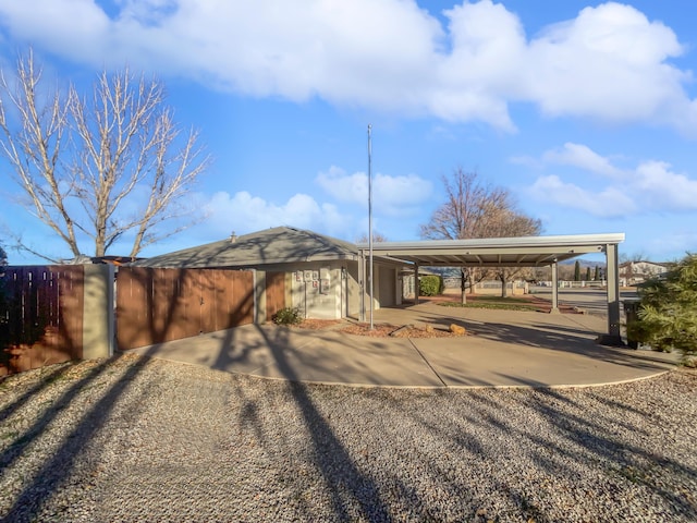 437 El Llano Ln NW, Los Ranchos, NM 87107 - view of parking / parking lot featuring a carport, gravel driveway, and a garage