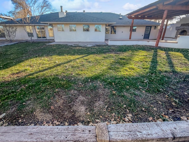 back of house with a yard and a patio