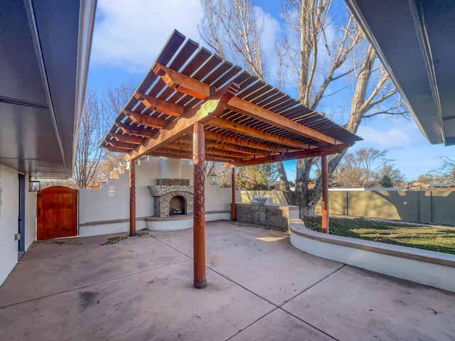 view of patio / terrace with a grill, exterior kitchen, and an outdoor stone fireplace