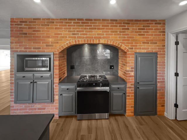 kitchen featuring gray cabinetry, light hardwood / wood-style floors, and appliances with stainless steel finishes