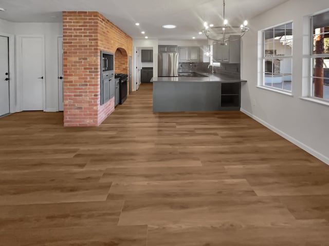 437 El Llano Ln NW, Los Ranchos, NM 87107 - kitchen featuring freestanding refrigerator, a peninsula, a chandelier, recessed lighting, and wood finished floors