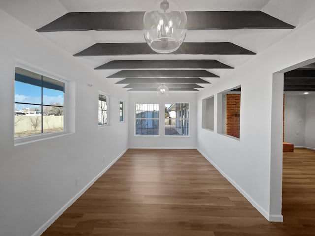 corridor featuring plenty of natural light, lofted ceiling with beams, and hardwood / wood-style flooring