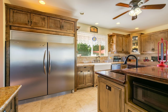 kitchen featuring ceiling fan, sink, light tile patterned floors, and stainless steel appliances