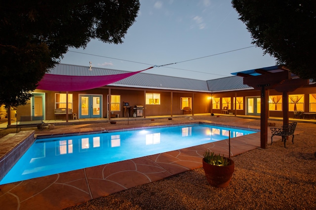 outdoor pool featuring a patio and french doors