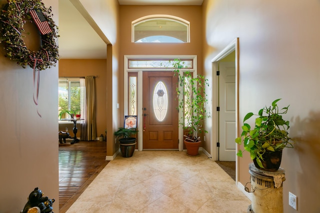 foyer entrance featuring light tile patterned floors and a high ceiling