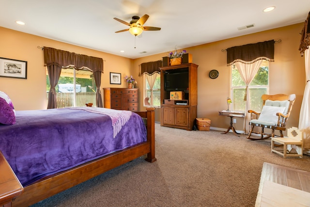 bedroom with light carpet, access to exterior, multiple windows, and ceiling fan