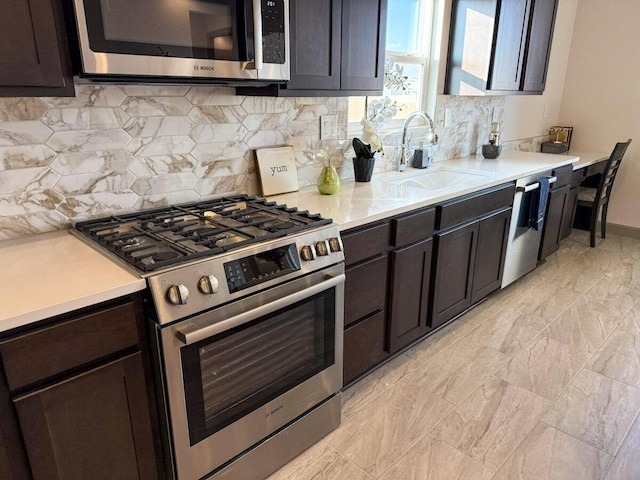 kitchen with tasteful backsplash, appliances with stainless steel finishes, sink, and dark brown cabinets