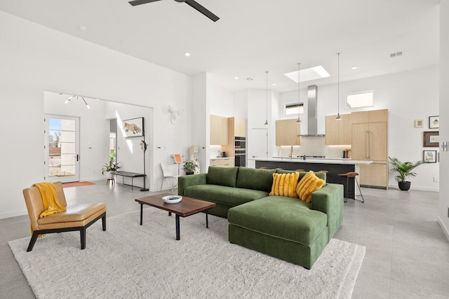 living room featuring a high ceiling and ceiling fan