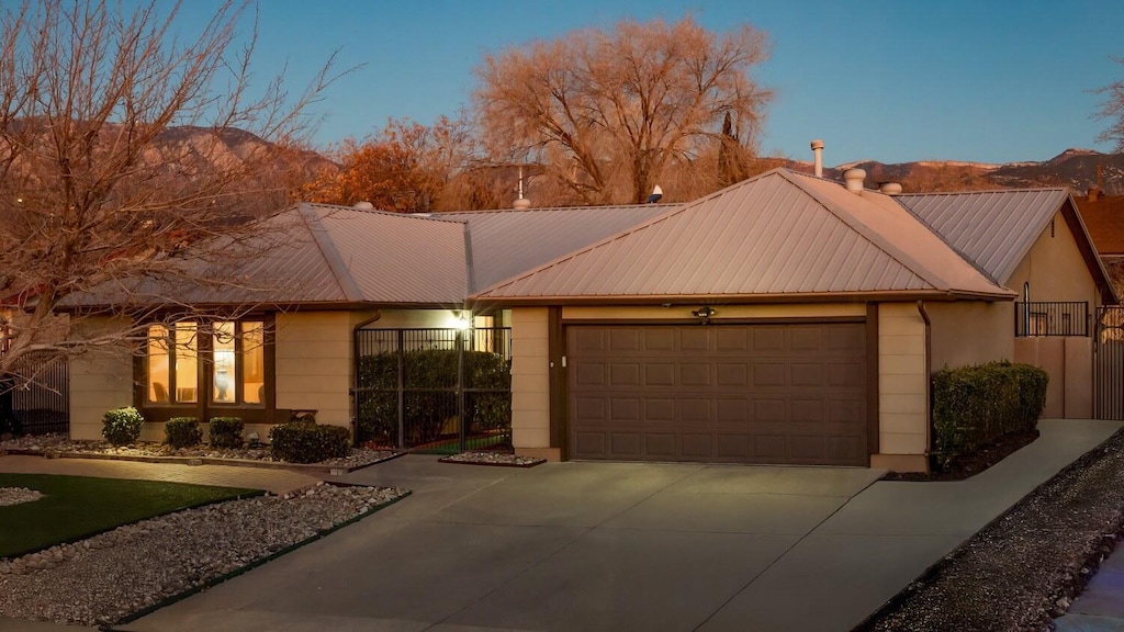 single story home with a garage and a mountain view