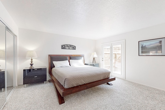 carpeted bedroom with a closet and a textured ceiling