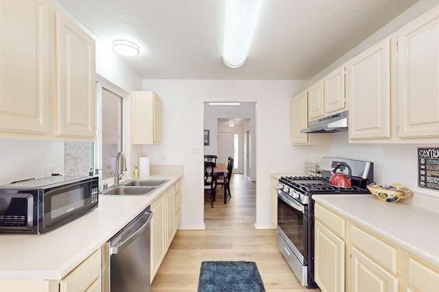 kitchen with appliances with stainless steel finishes, light hardwood / wood-style flooring, and sink