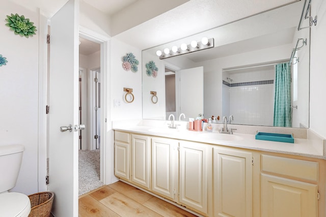 bathroom featuring wood-type flooring, vanity, toilet, and a shower with curtain