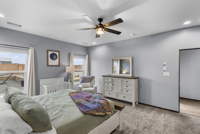 carpeted bedroom with multiple windows, recessed lighting, visible vents, and baseboards