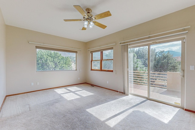 carpeted spare room featuring ceiling fan