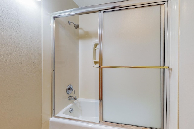 bathroom featuring combined bath / shower with glass door