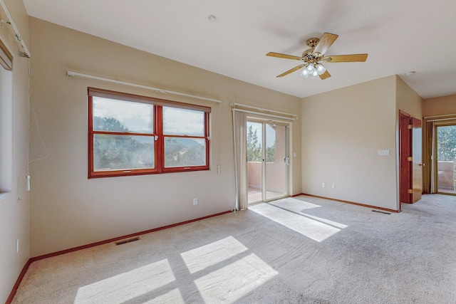 spare room with ceiling fan and light colored carpet