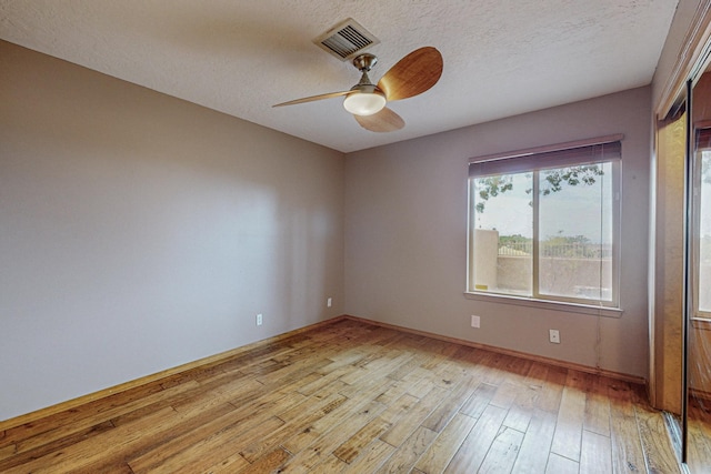 unfurnished room featuring ceiling fan, a textured ceiling, and light hardwood / wood-style flooring