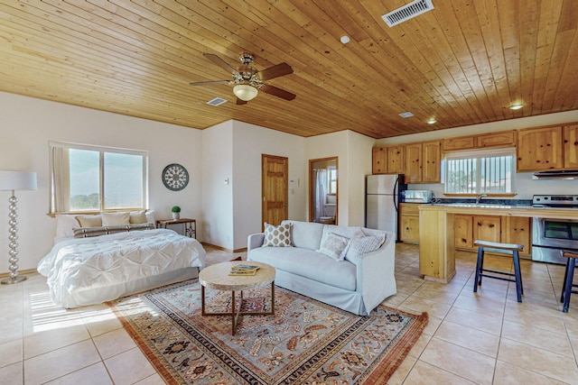 bedroom featuring light tile patterned floors, wood ceiling, sink, and stainless steel refrigerator