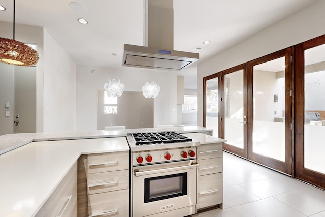 kitchen with french doors, hanging light fixtures, island exhaust hood, premium stove, and light brown cabinetry