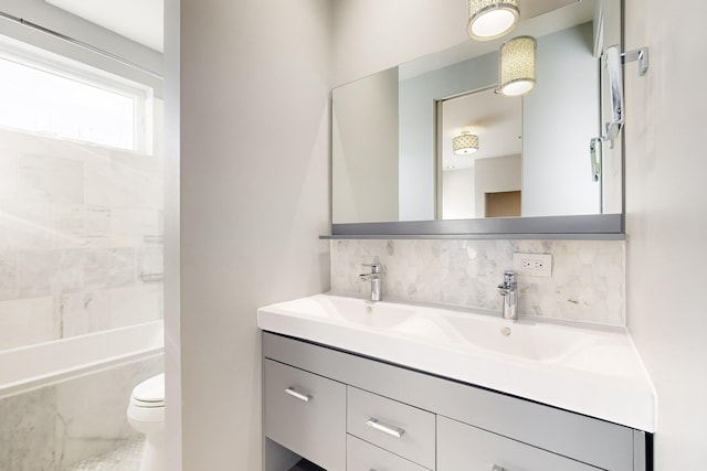 full bathroom with backsplash, vanity, toilet, and tiled shower / bath