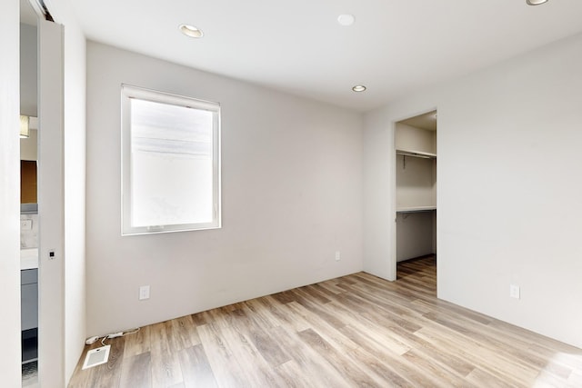 unfurnished bedroom with light hardwood / wood-style floors and a closet