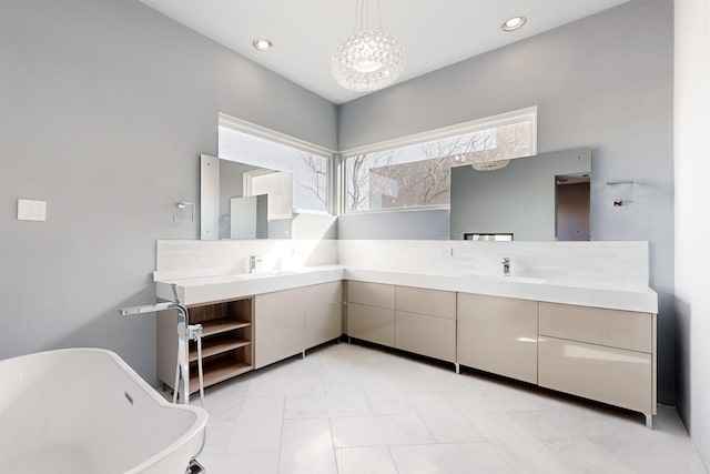 bathroom with a washtub, vanity, and an inviting chandelier