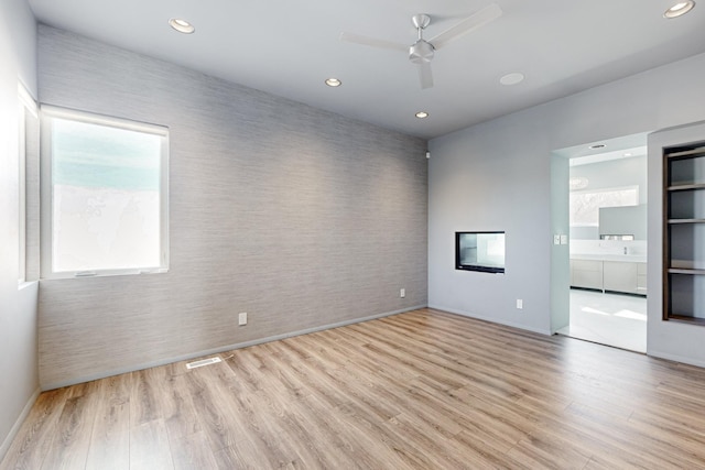 spare room featuring ceiling fan and light hardwood / wood-style floors