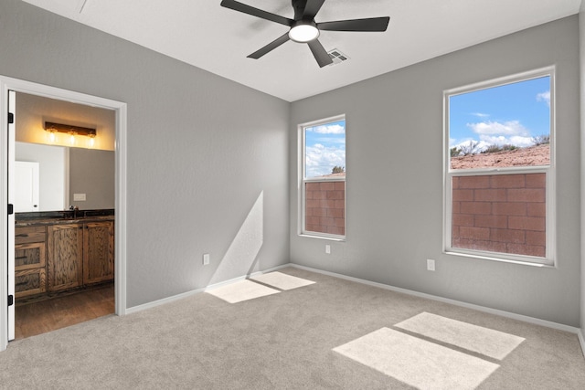 unfurnished bedroom featuring ceiling fan, sink, and light colored carpet