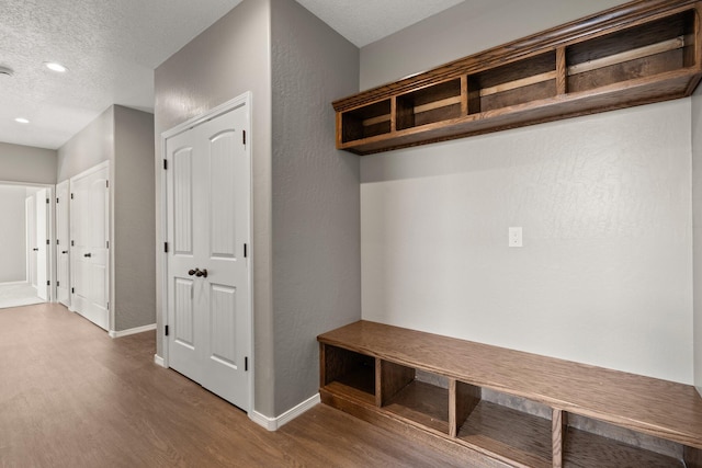 mudroom with wood-type flooring and a textured ceiling