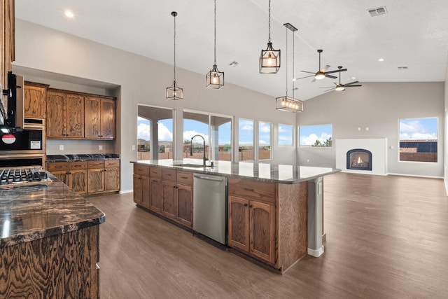 kitchen featuring a large island, sink, dark hardwood / wood-style flooring, decorative light fixtures, and appliances with stainless steel finishes