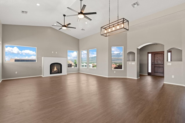 unfurnished living room featuring ceiling fan, dark wood-type flooring, and high vaulted ceiling