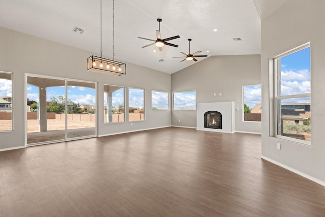 unfurnished living room with ceiling fan, high vaulted ceiling, and dark wood-type flooring