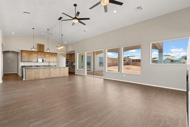 unfurnished living room featuring high vaulted ceiling, ceiling fan, dark wood-type flooring, and sink