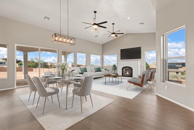 dining room featuring dark hardwood / wood-style flooring, high vaulted ceiling, and ceiling fan