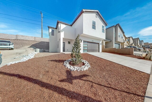 13601 Covered Wagon Ave SE, Albuquerque, NM 87123 - view of property exterior featuring driveway, an attached garage, fence, stucco siding, and a residential view