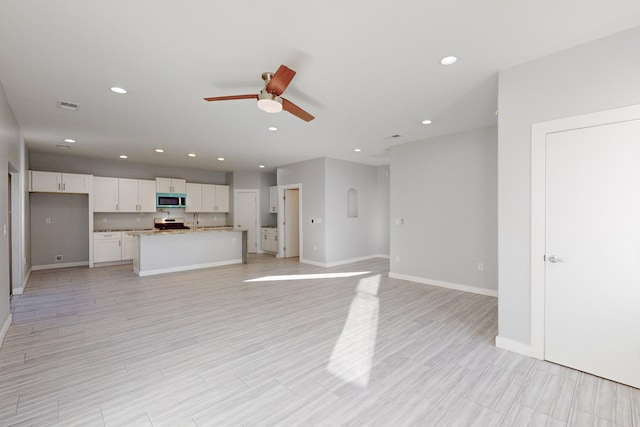 unfurnished living room featuring light hardwood / wood-style floors and ceiling fan