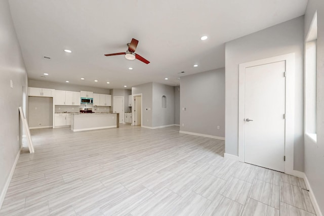 unfurnished living room with ceiling fan