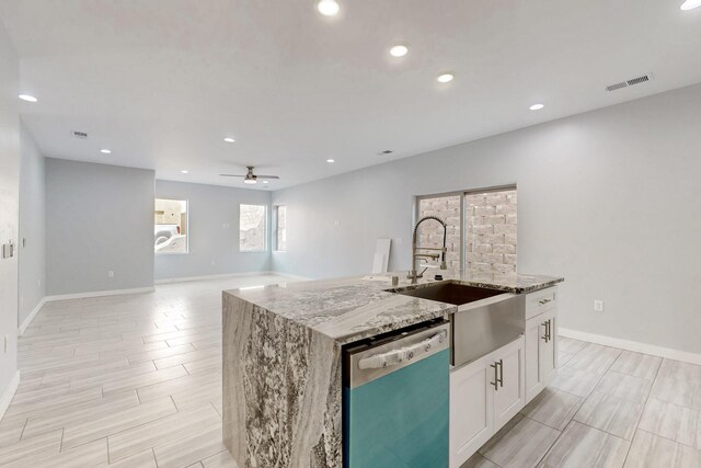 13601 Covered Wagon Ave SE, Albuquerque, NM 87123 - kitchen featuring light stone counters, a sink, ceiling fan, white cabinets, and dishwashing machine