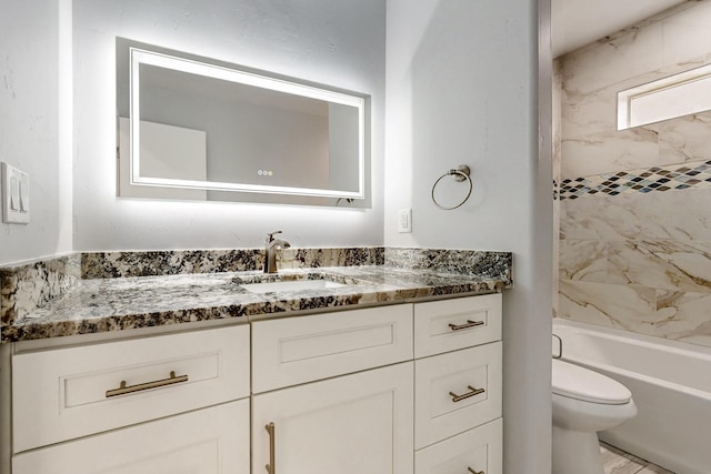 full bathroom featuring tiled shower / bath combo, vanity, and toilet