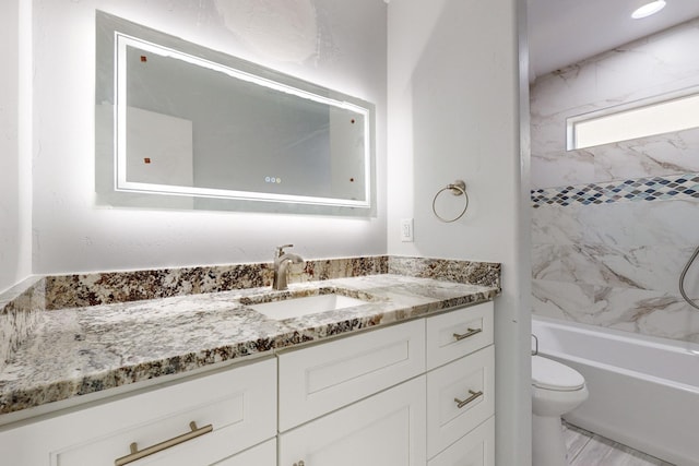 full bathroom featuring tiled shower / bath combo, vanity, and toilet