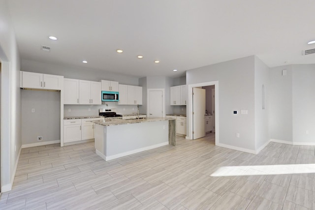 kitchen with white cabinetry, stainless steel electric range oven, and a center island with sink