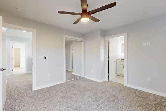 unfurnished bedroom with light carpet, a closet, ceiling fan, and ensuite bathroom